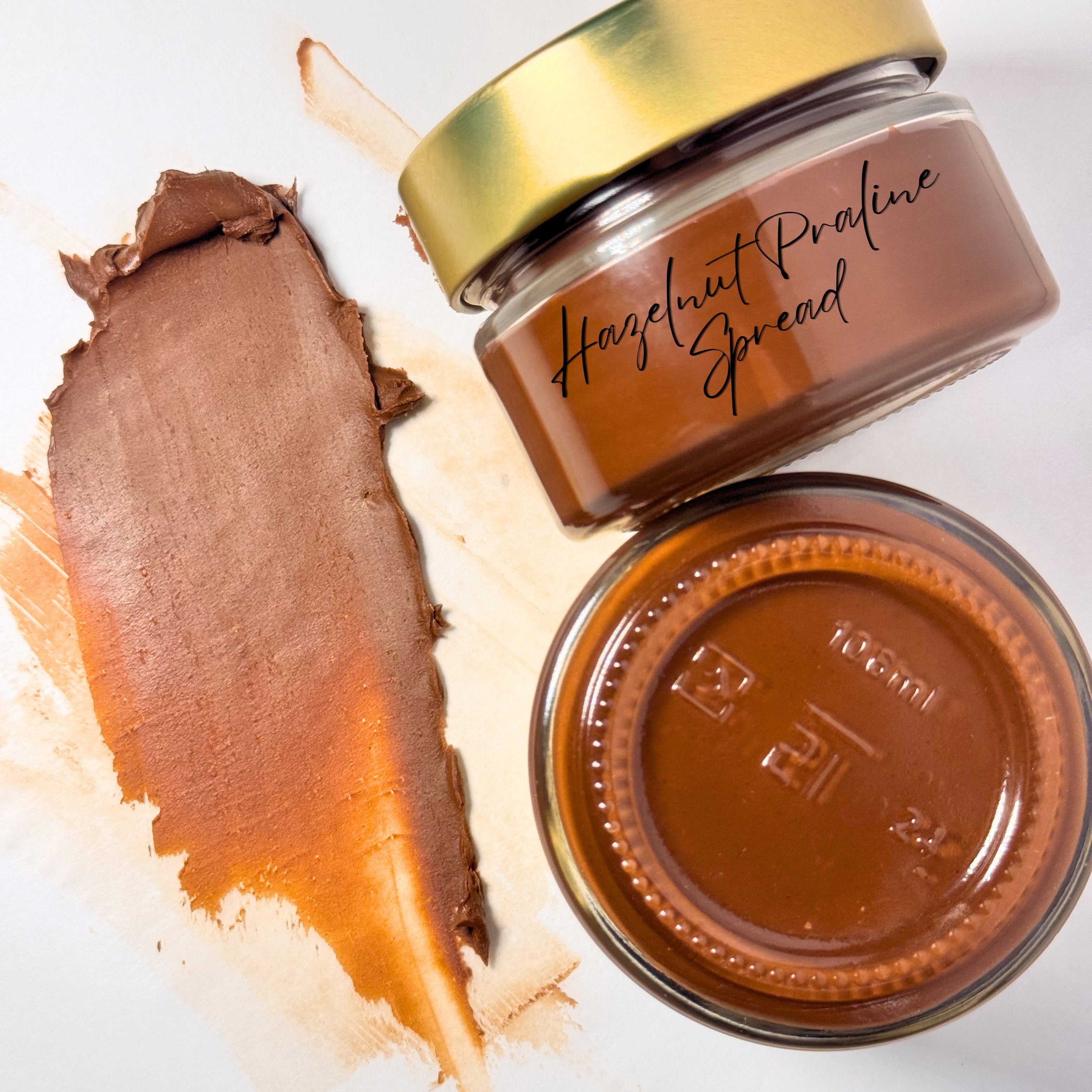 Jar of Hazelnut Praline Spread with a gold lid on a white background