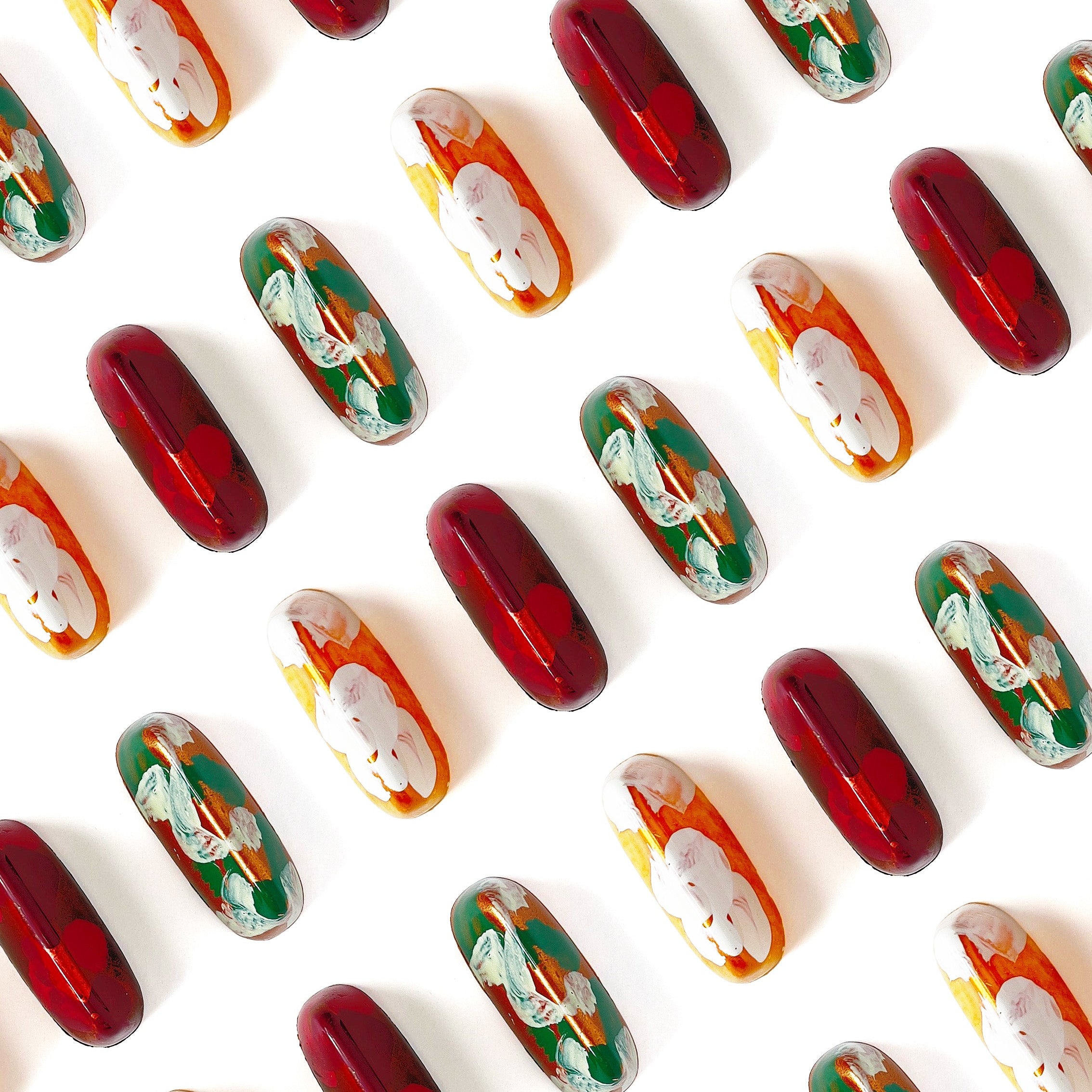 Pattern of red, green, and gold chocolate bonbons on a white background