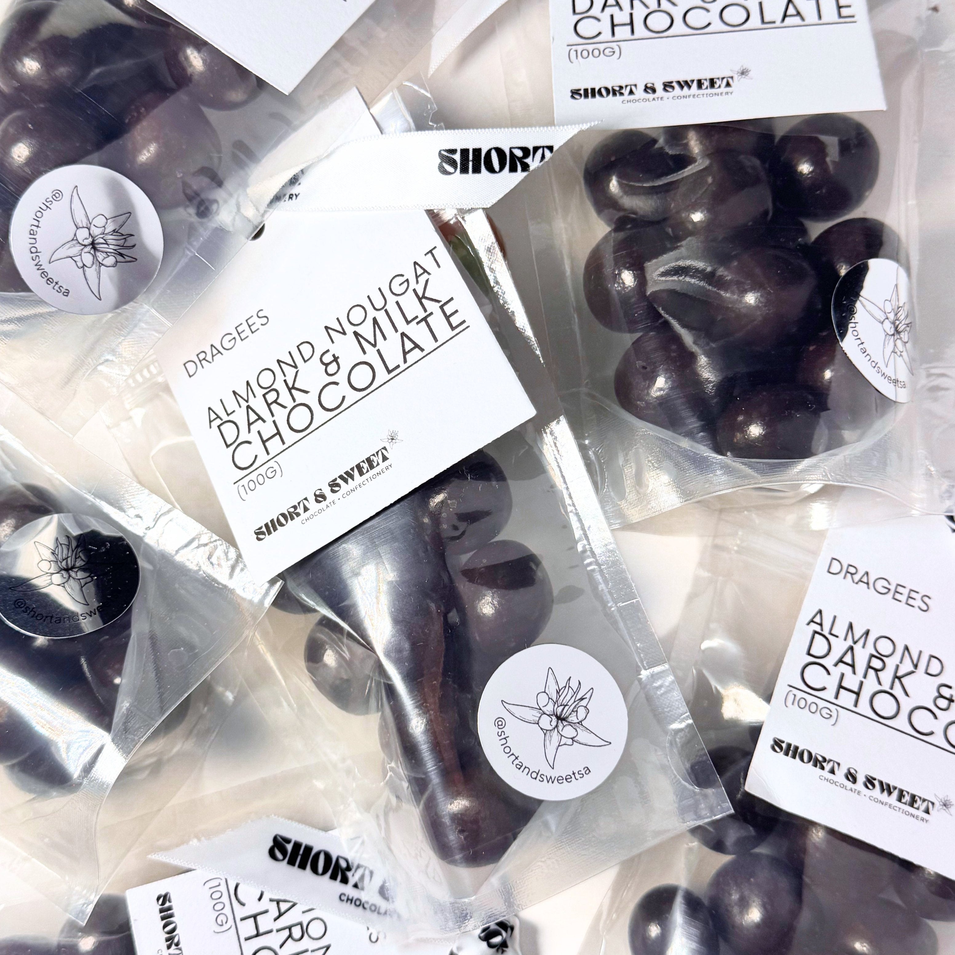 Almond nougat dark & milk chocolate dragees in clear packaging with visible branding.