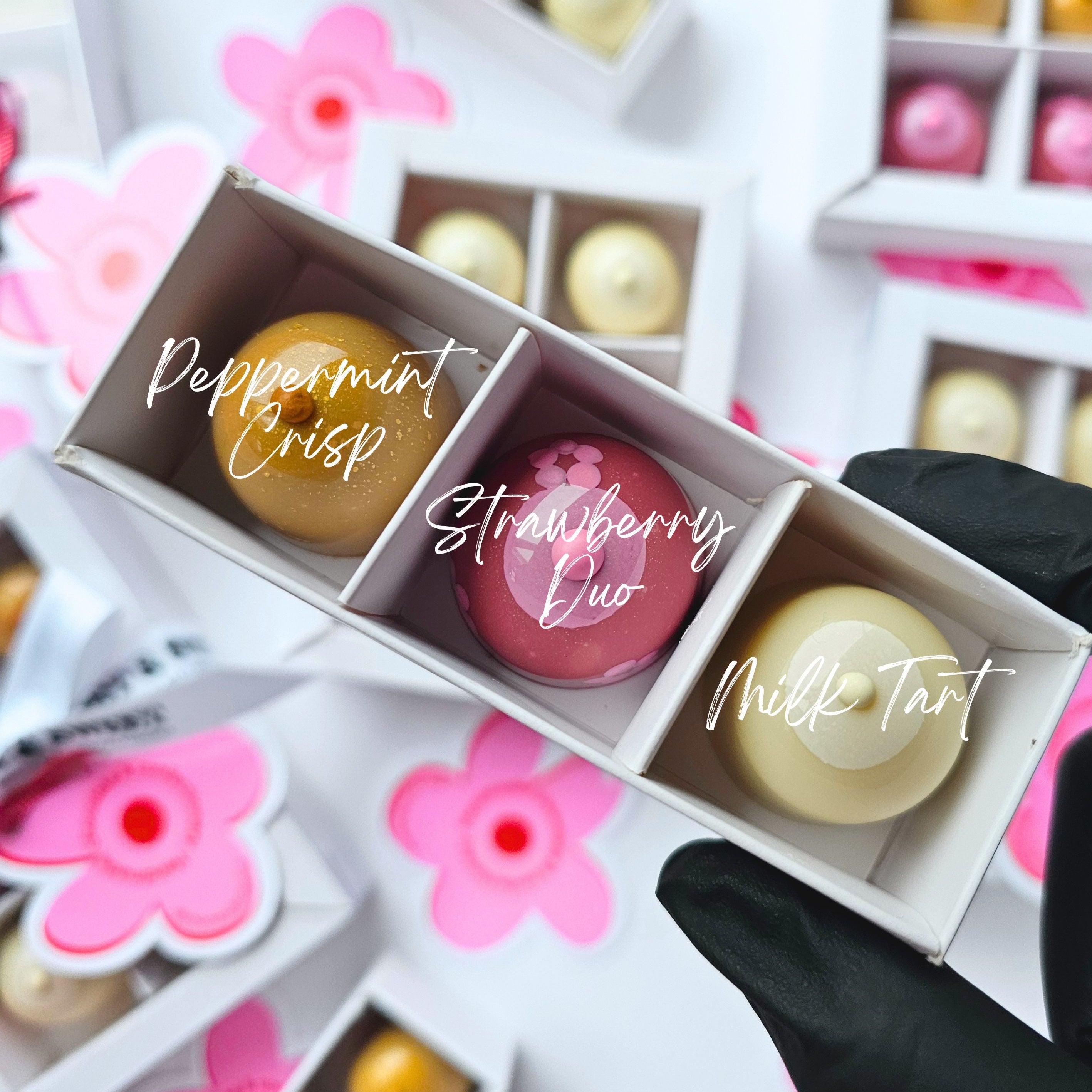 Assorted chocolate truffles in small boxes with floral decorations
